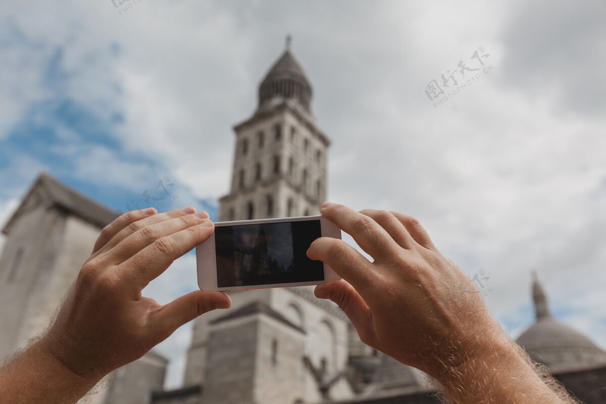 旅游手持智能手机的游客在法国佩里盖拍照观光地标风景
