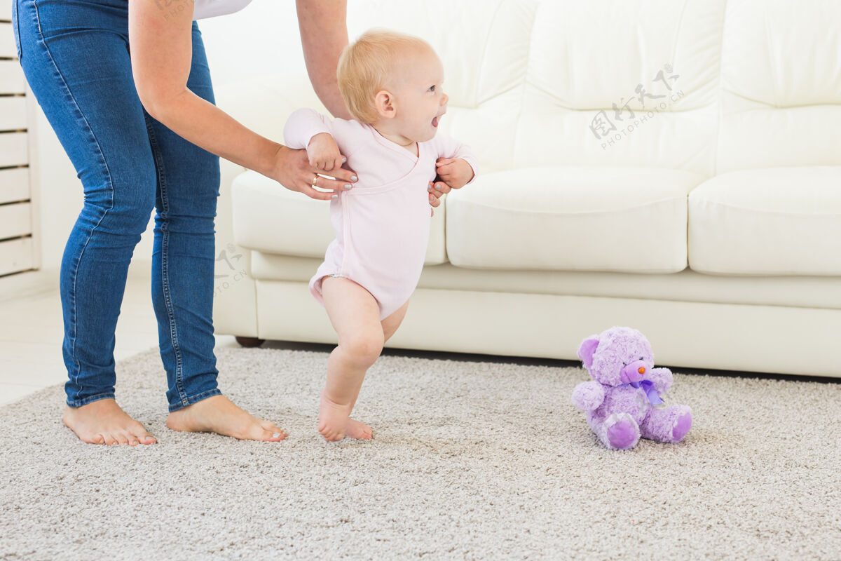 欢呼小女婴在妈妈的帮助下迈出了第一步步骤照顾走路