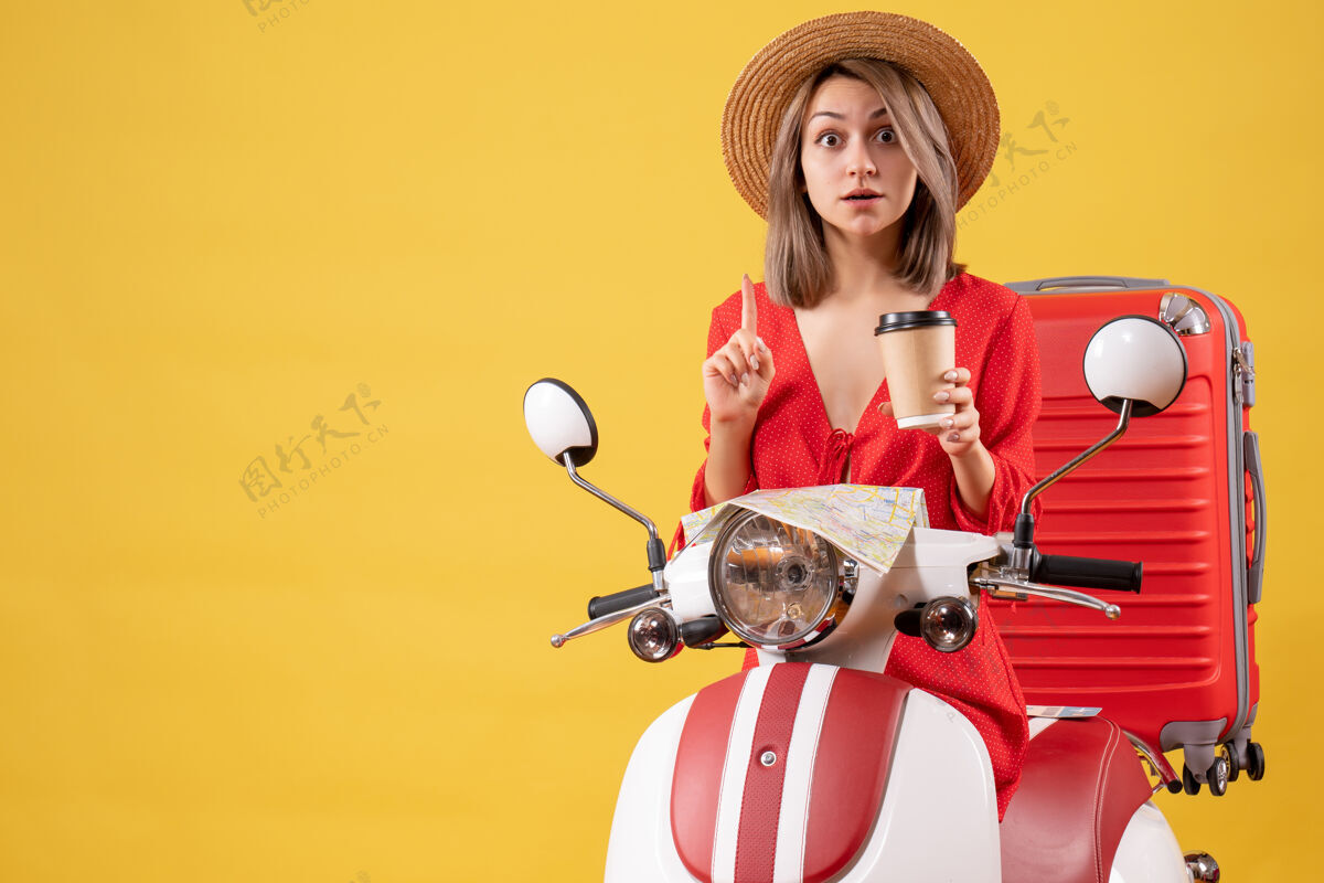 杯子一位穿着红裙子的年轻女士拿着咖啡杯 坐在轻便摩托车旁边人咖啡时尚