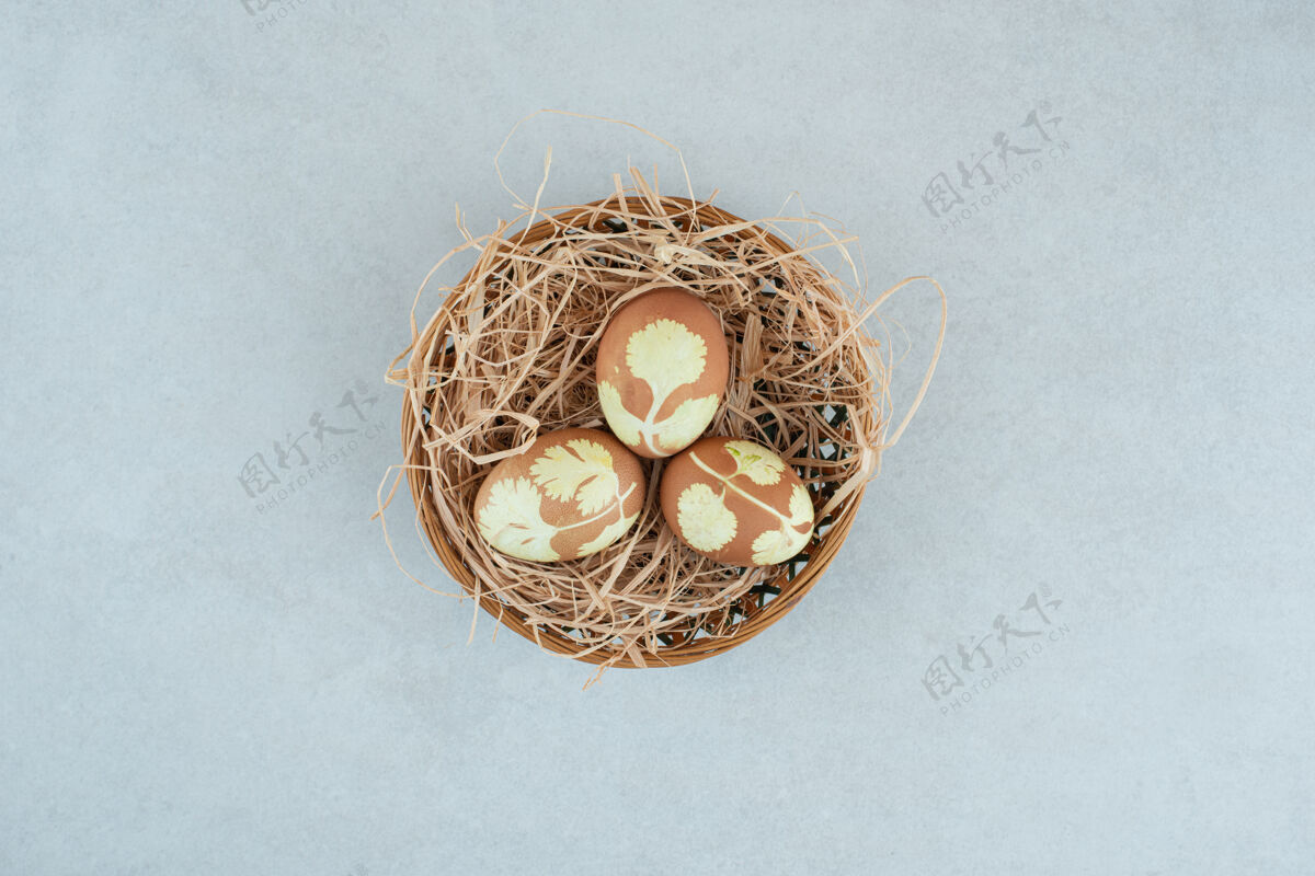 美味在柳条篮子上的干草里画了三个鸡蛋柳条篮子干草