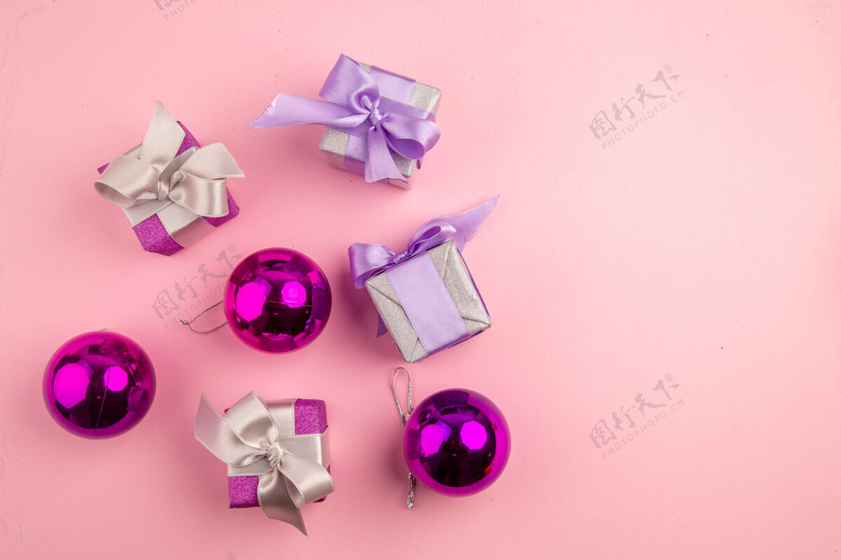 花顶视图的小礼物与圣诞树玩具在粉红色的表面爱树花