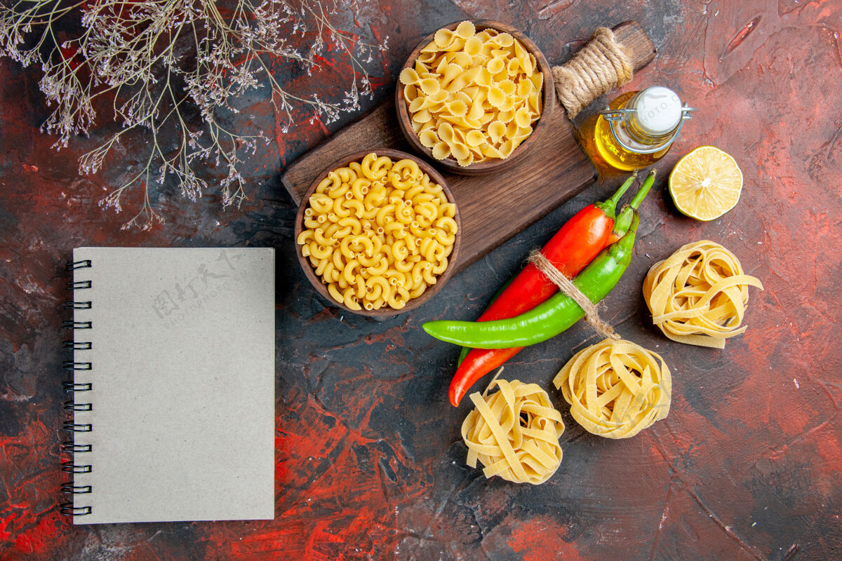 膳食生面团和辣椒用绳子绑在一起 油瓶柠檬蒜和笔记本放在五颜六色的桌子上午餐食物混合物