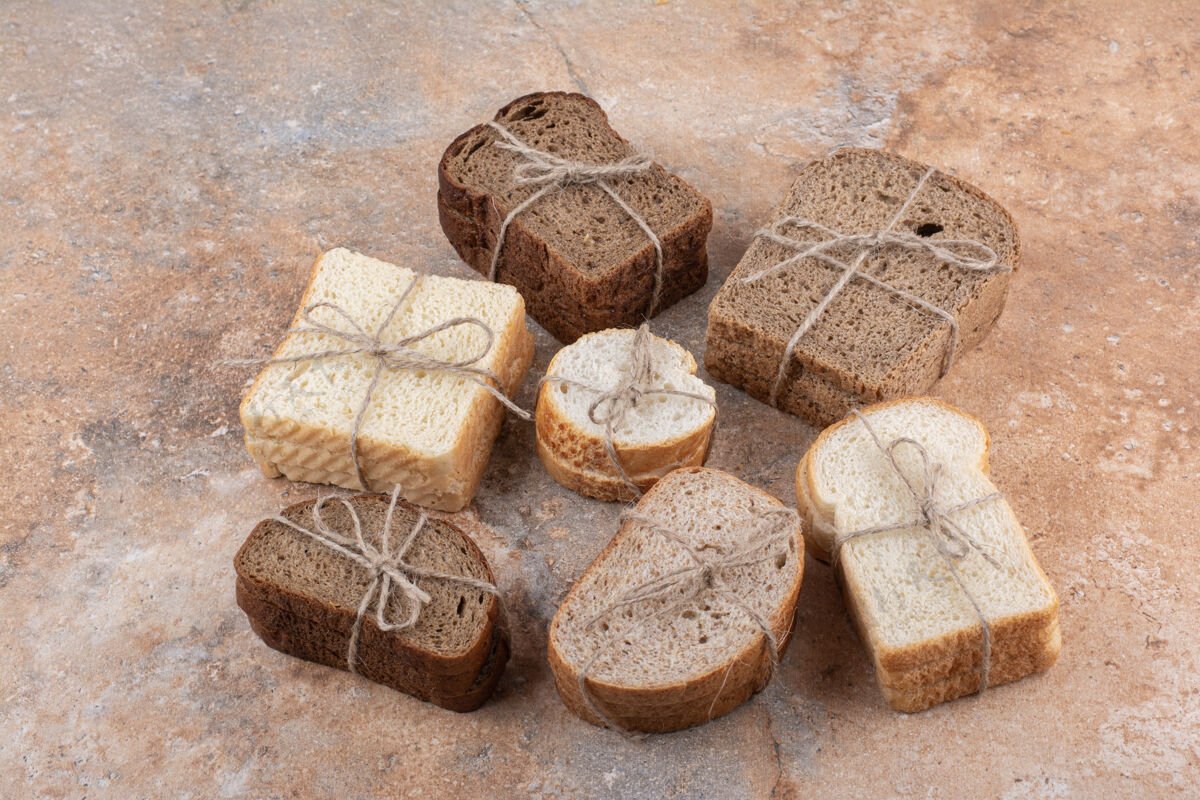分类各种各样的面包堆在大理石背景上绳索美味面包房