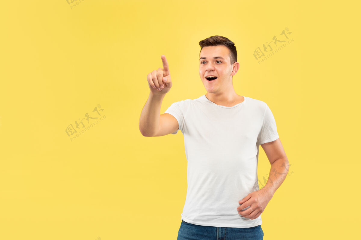 长相黄色工作室背景上的白人年轻人半身肖像穿着衬衫的漂亮男模人类情感的概念 面部表情 销售 广告触摸一个空的搜索栏表情人专业