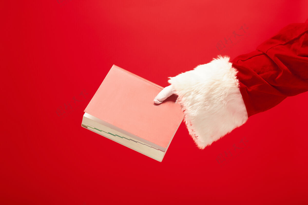 鞠躬圣诞老人的手拿着一个红色的笔记本礼物手套礼物