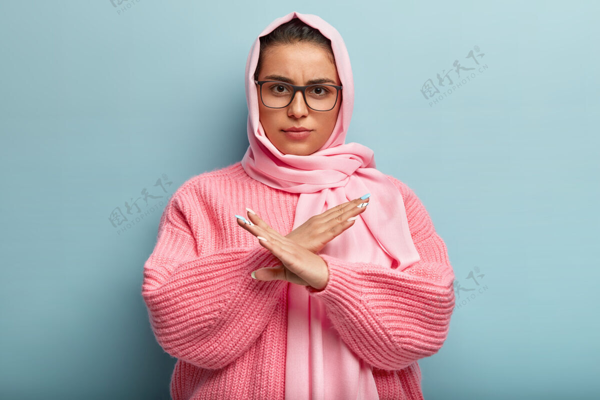 不同意不满严重的黑发女性 具体的外表 在禁止中显示交叉手势 说不要问我 表示不同意和不满停止 够了 拒绝概念阿拉伯语摆姿势夹克