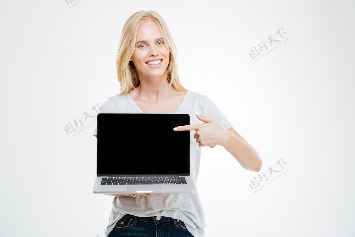 指向一个开朗的女孩的肖像显示空白笔记本电脑屏幕上的白色背景隔离专业人士行政人员技术