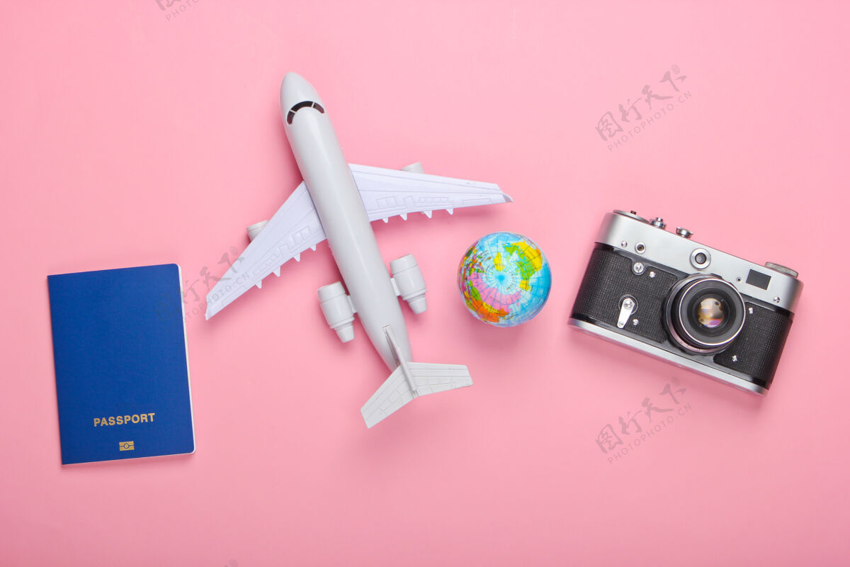 飞机旅游和旅游概念地球仪 护照 客机雕像和粉红色粉彩墙上的相机顶视图平躺鞭打时尚计划