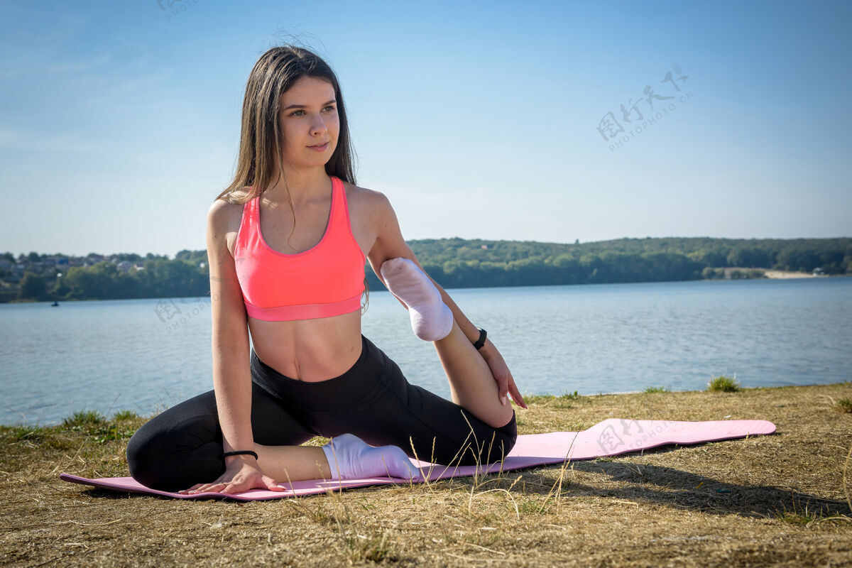 腿部年轻漂亮的健身女士做瑜伽姿势 在大自然中伸展健康的生活方式运动姿势女孩