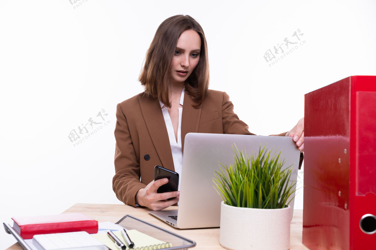 生活方式一个穿着西装的年轻女子在一台白色背景的笔记本电脑前工作孤立的肖像微笑女性