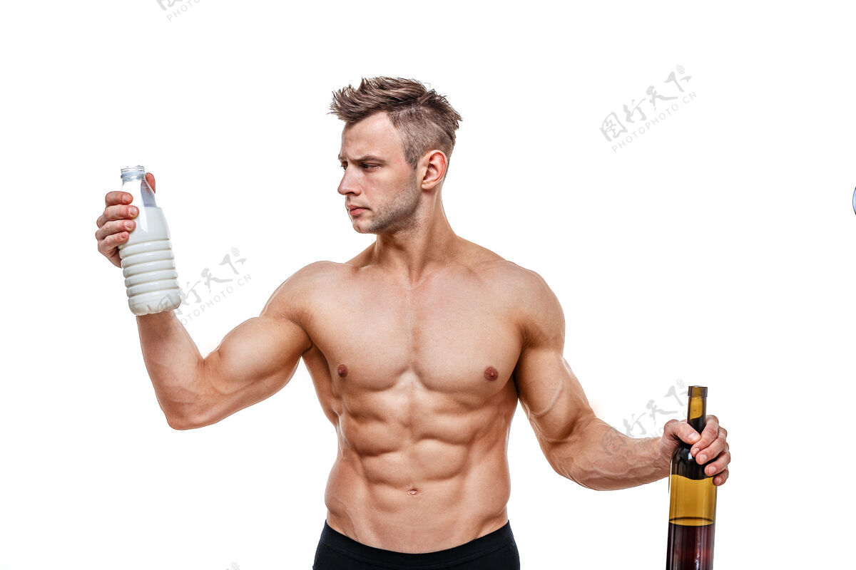 健康运动型男人拿着葡萄酒和牛奶 面对一种选择 健康的生活方式或酒精健康 运动 选择 健康的食物和健康的生活方式理念饮料意识快乐