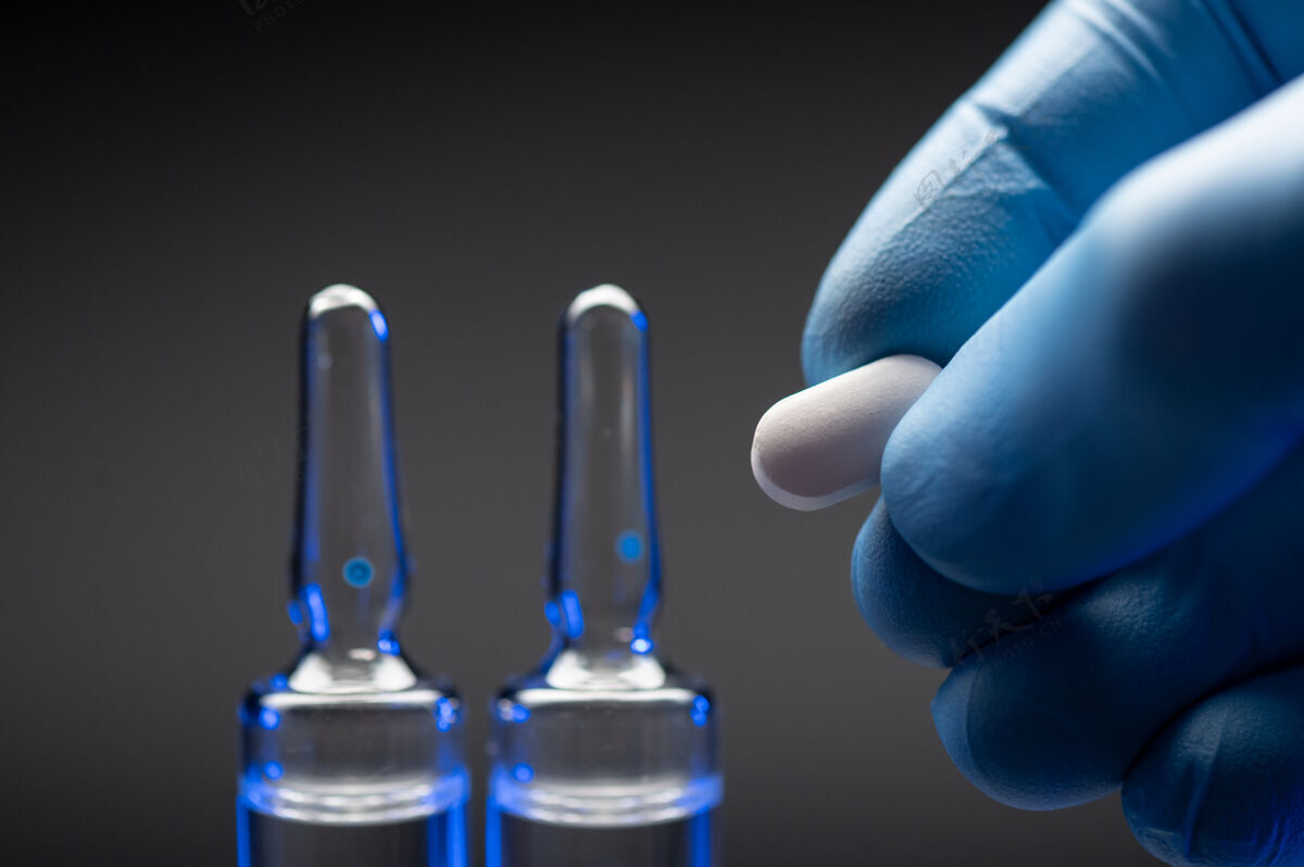药物手戴手套 手持药丸 是医疗保健和疫苗接种的理念治疗小瓶研究