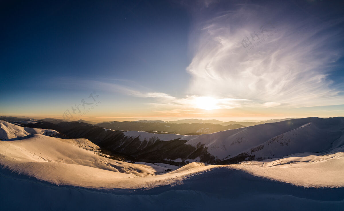 阳光雄伟的雪山坐落在山上的一个阳光明媚的冬日与蓝天在欧洲滑雪胜地阿尔卑斯山雪山谷