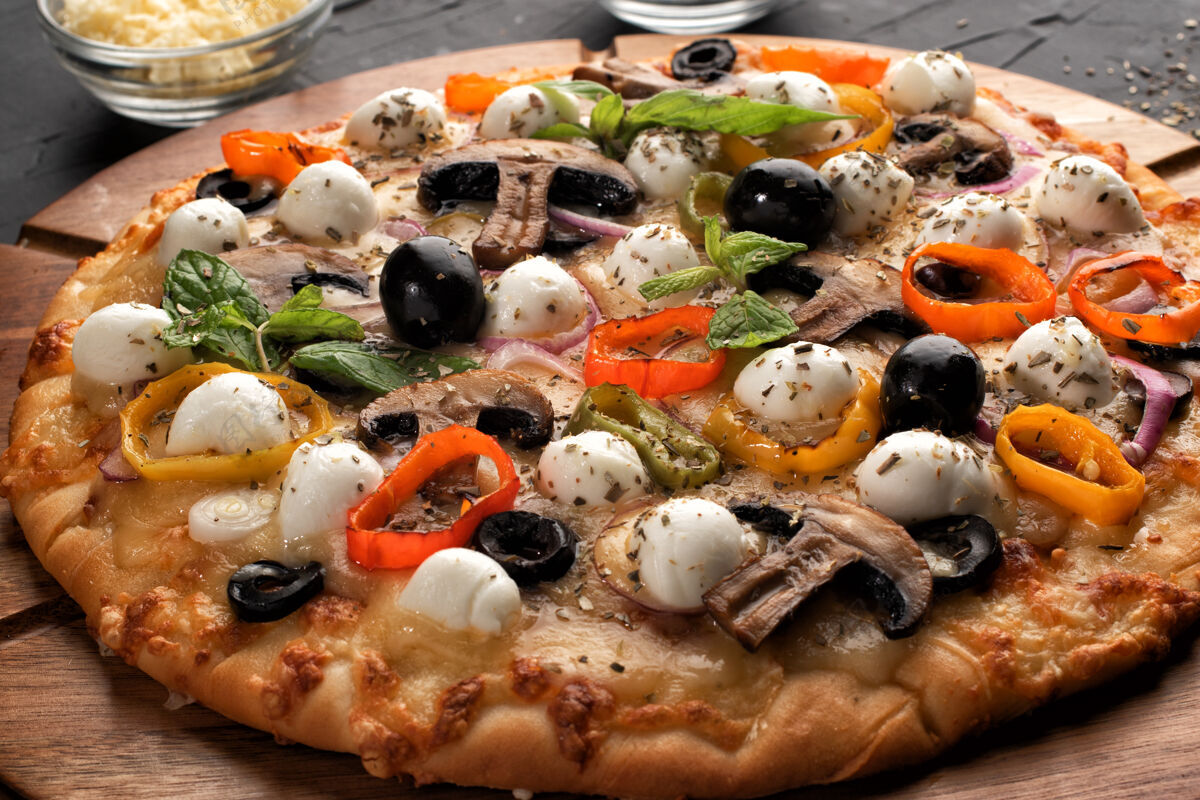 快餐比萨配马苏里拉 橄榄和蘑菇意大利菜黑面包上做比萨饼的原料背景.概念为餐馆或比萨店做广告奶酪快餐热