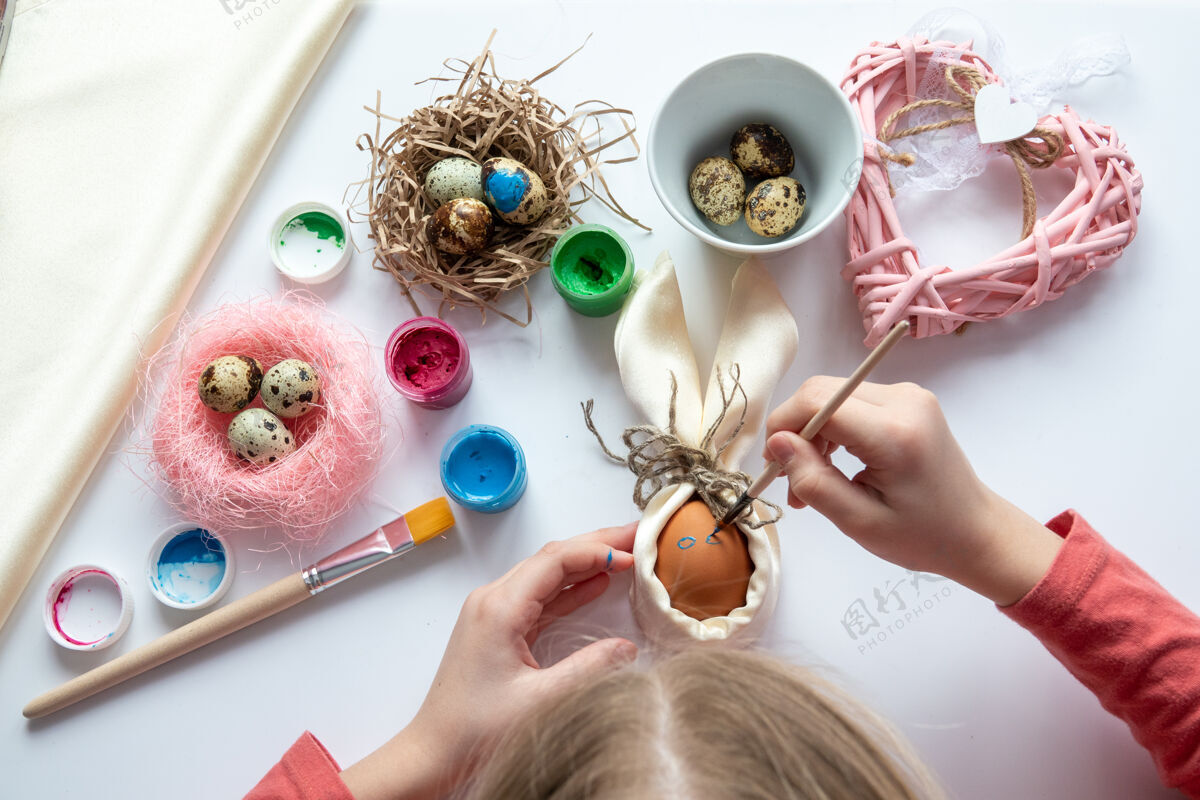 父母这个女孩正在为复活节做珠子和鸡蛋的柳条女人篮子Diy