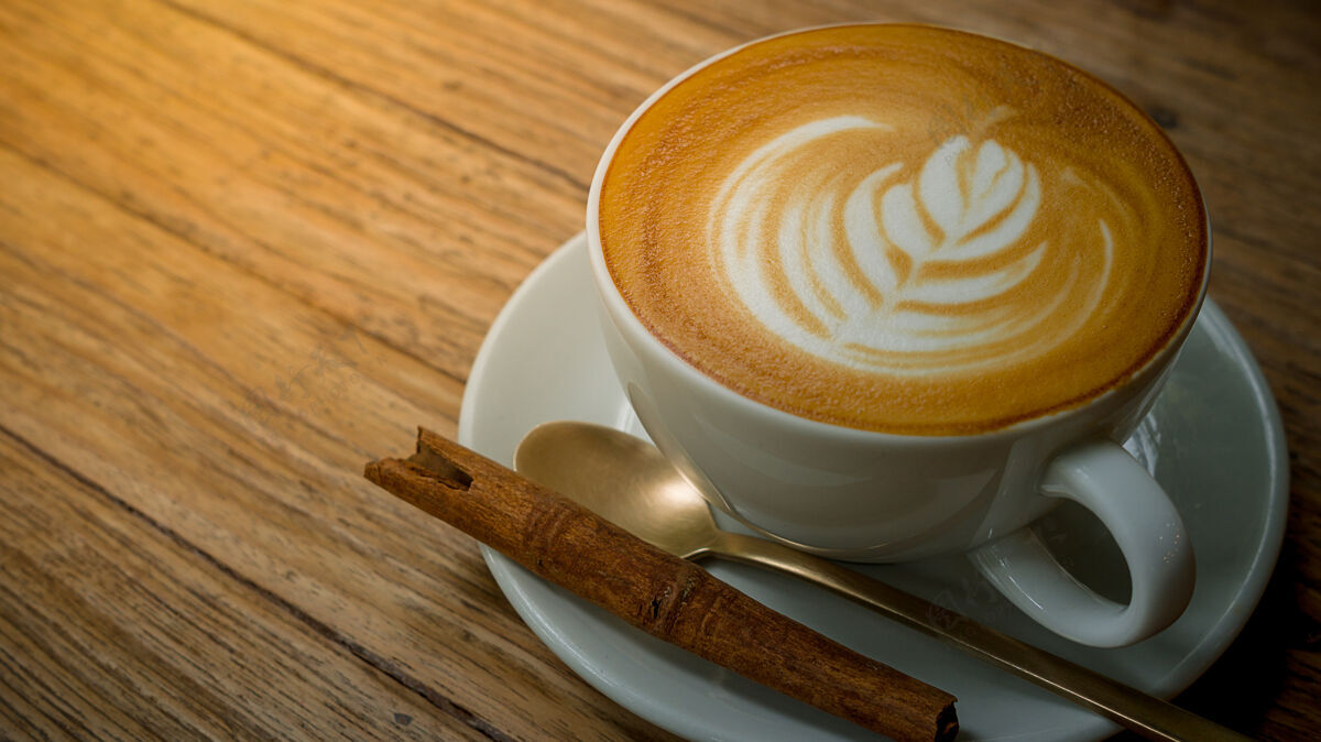 早餐一杯咖啡在木桌上咖啡馆奶油咖啡因