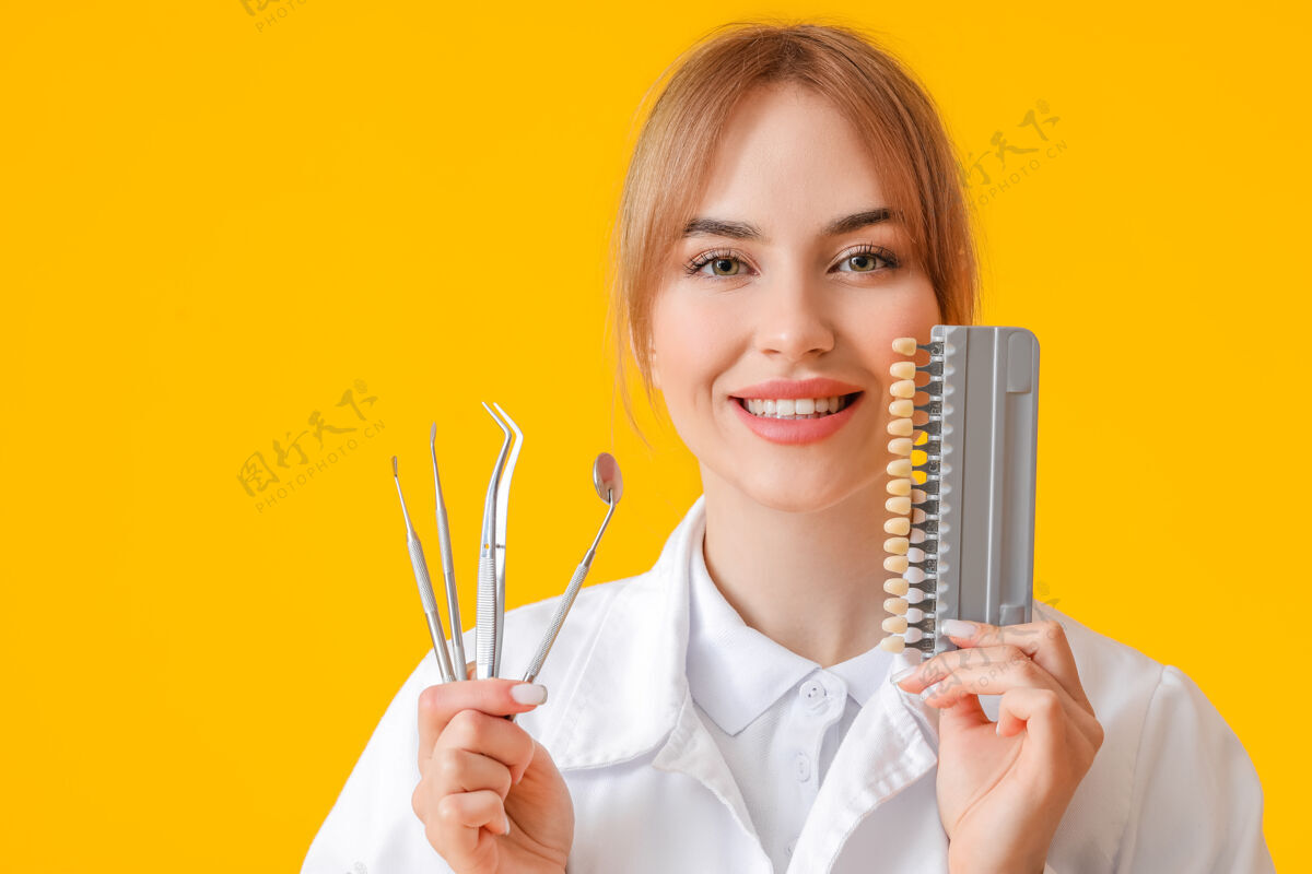 口腔女牙医用工具和牙齿颜色表在黄色表面预防医疗牙齿