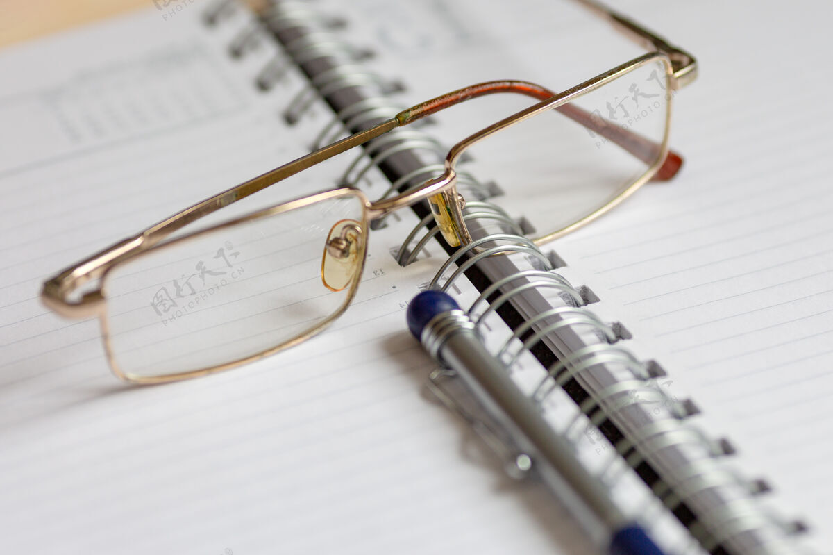 笔记本把眼镜和笔放在打开的笔记本上 书桌办公室创意