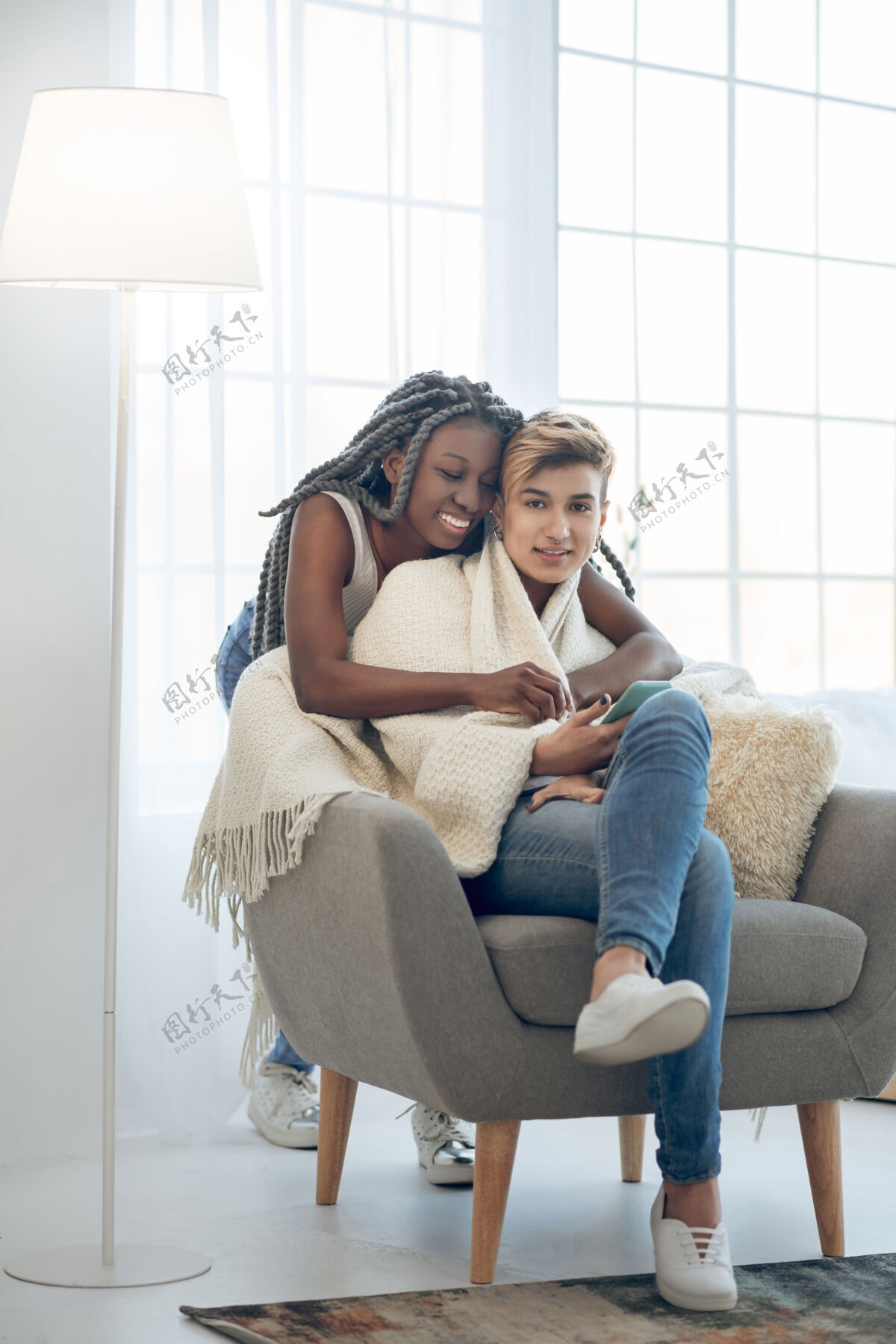 非裔美国人快乐女孩非洲美国微笑女孩拥抱坐在椅子上的女朋友同性恋关系阁楼
