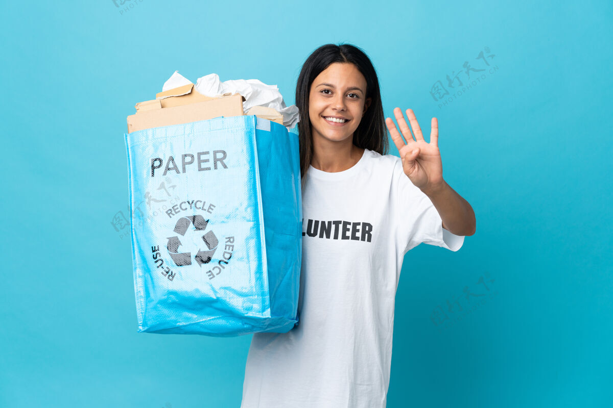 女性年轻女子拿着一个装满纸的回收袋 高兴地用手指数着四个再利用手指环境