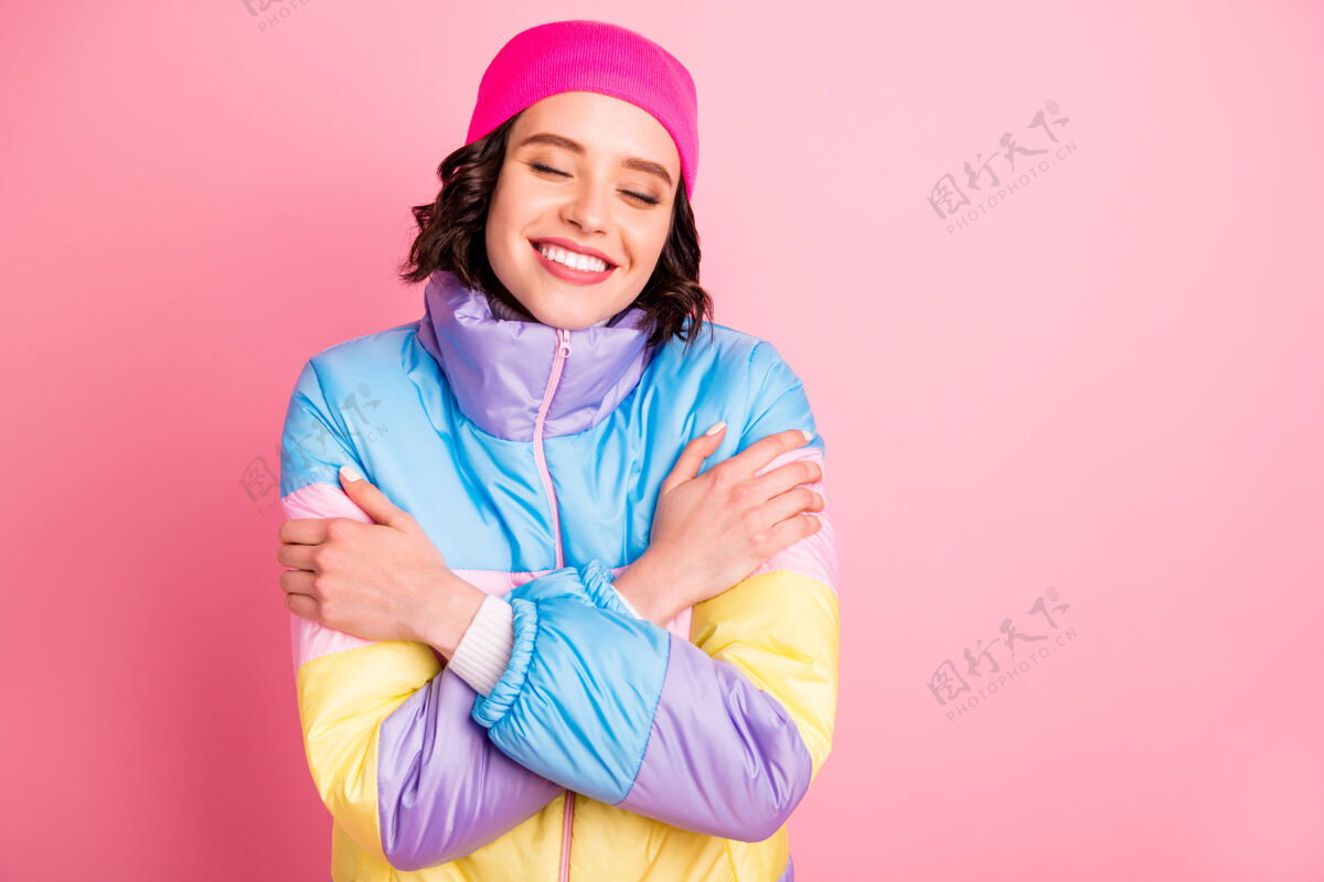 年轻美女牵手的特写照片暖色外套隔离粉色背景寒冷快乐她自己