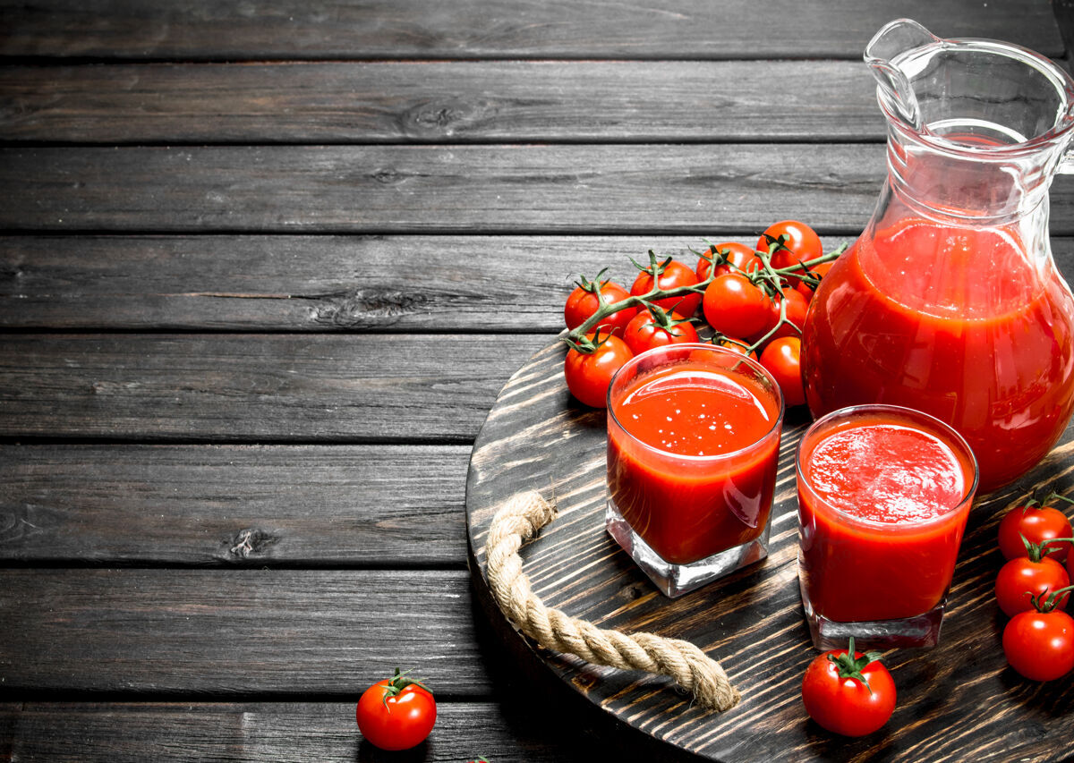 多汁的番茄汁放在罐子里 玻璃杯放在黑色木桌上的托盘上饮食成熟罐子
