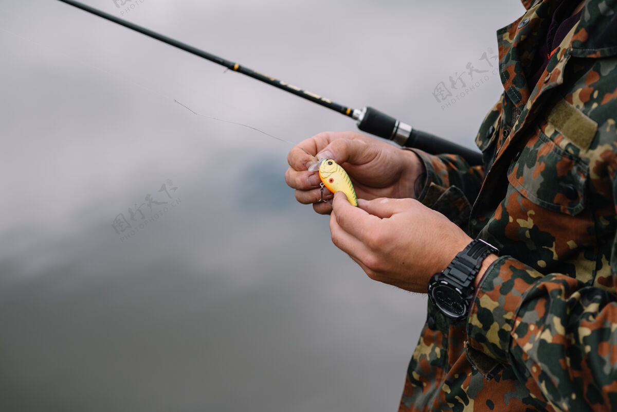 渔民一个渔夫拿着鱼竿在河岸上活动河流自然
