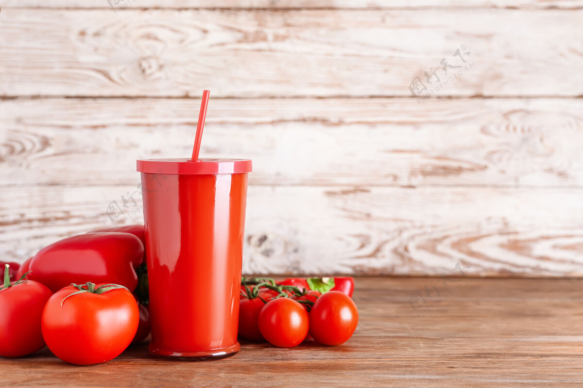 有机塑料杯的健康冰沙与番茄和甜椒在木制表面番茄搅拌机素食