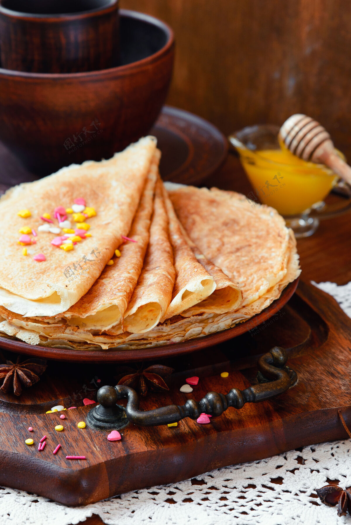 俄罗斯金煎饼 冷冻水果 装饰和蜂蜜在一个乡村风格早晨糖浆热的