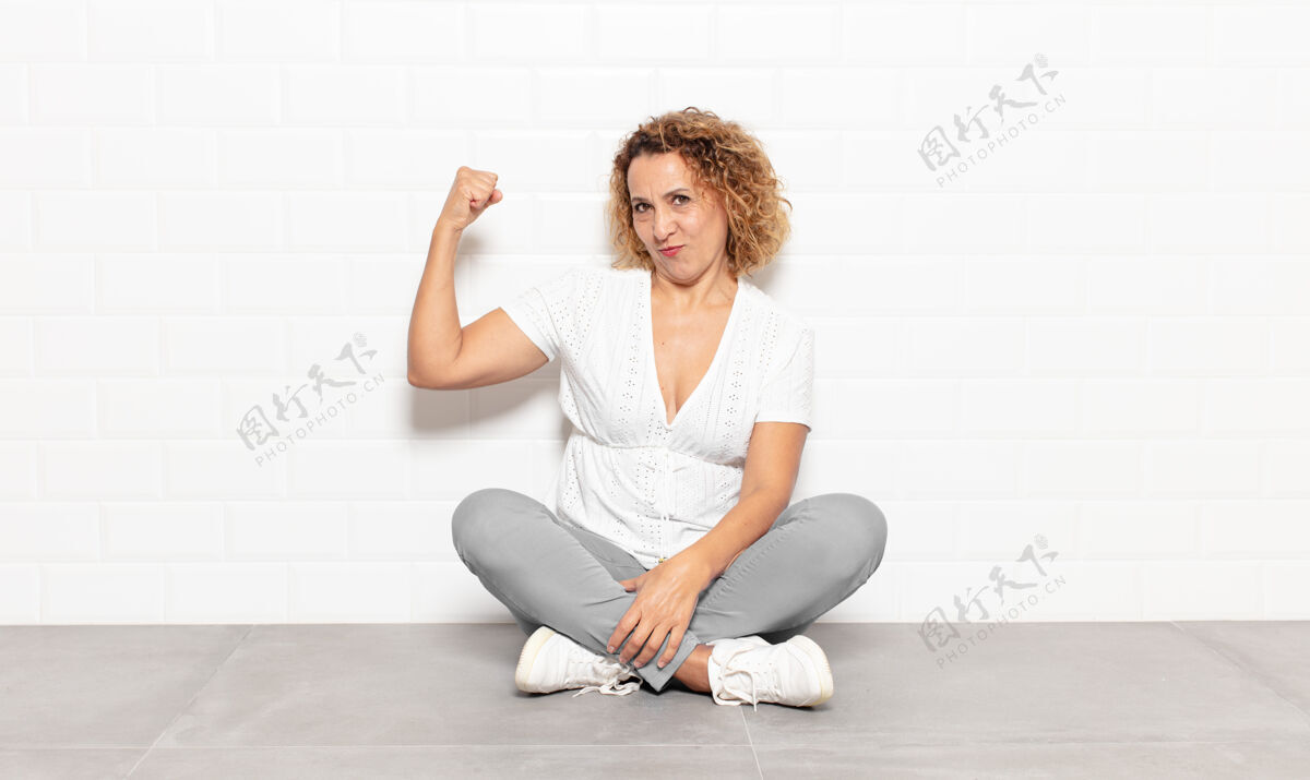 肌肉中年女性感觉快乐 满足和强大 屈曲适合和肌肉发达的肱二头肌 看起来强壮后 健身房快乐权力看