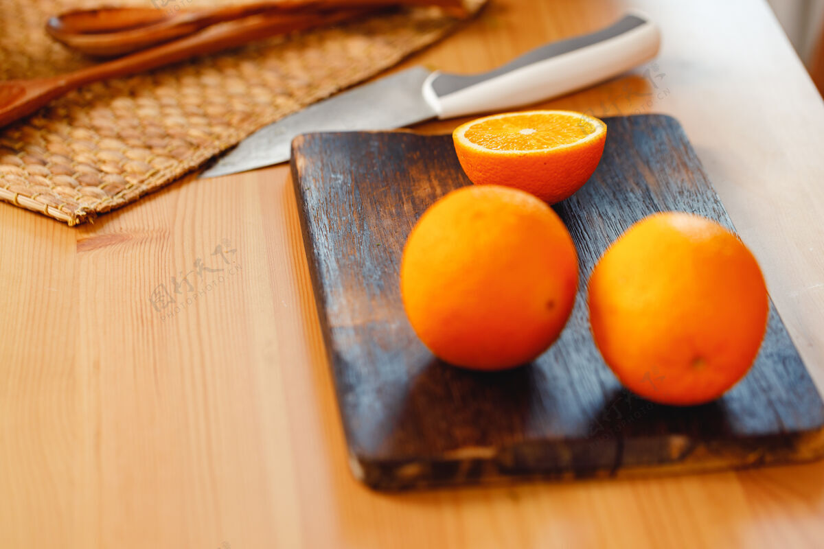切割新鲜的橙子放在木制砧板上 刀子放在餐桌上 特写切片刀有机
