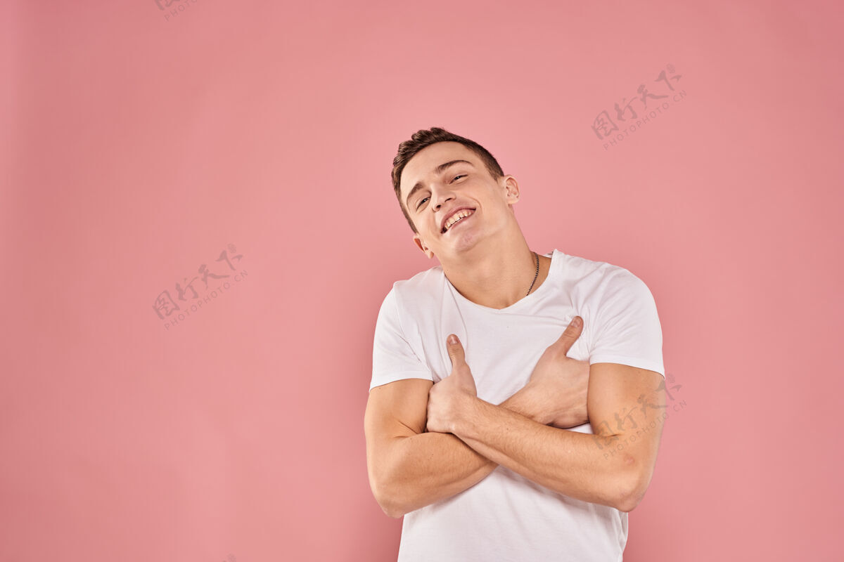 休闲情绪激动的男人用手做手势白色t恤粉色隔离墙年轻衬衫自信