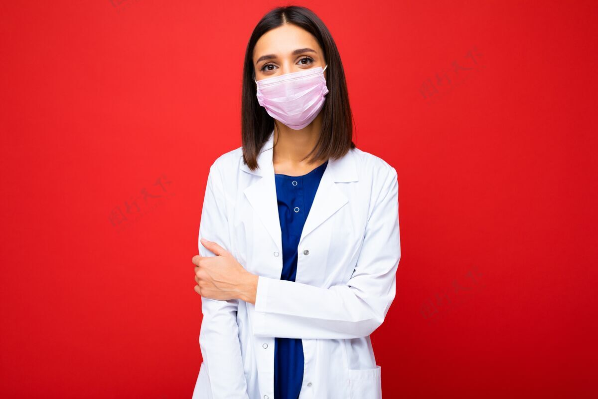 医疗女士在病毒防护口罩上贴上防冠状病毒的白色医用外套 隔离在背景上面罩药物冠状病毒
