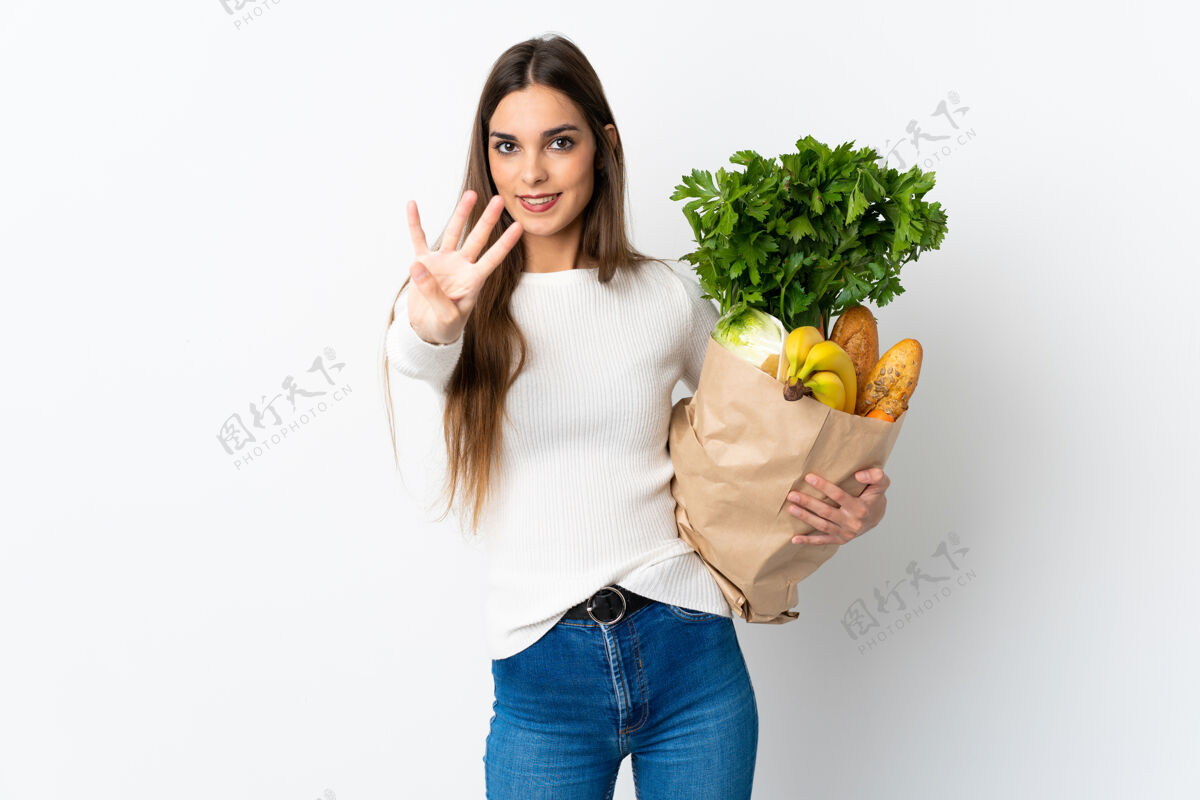 女性年轻的白种女人买了一些白色背景的食物 高兴地用手指数着四个女人饮食食物