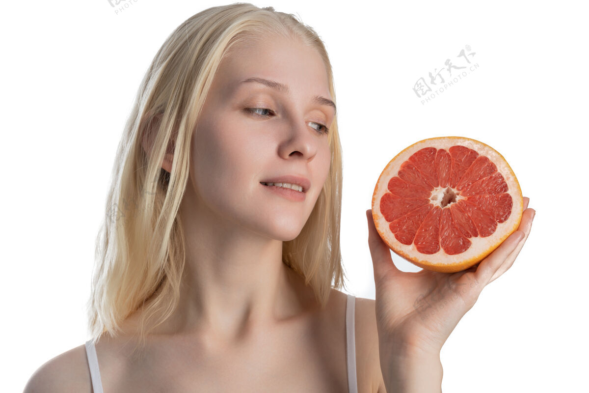 女孩美丽的肖像一个迷人的性感的年轻女子长发孤立地站在灰色的墙上 显示一半的葡萄柚 摆姿势食物柚子健康