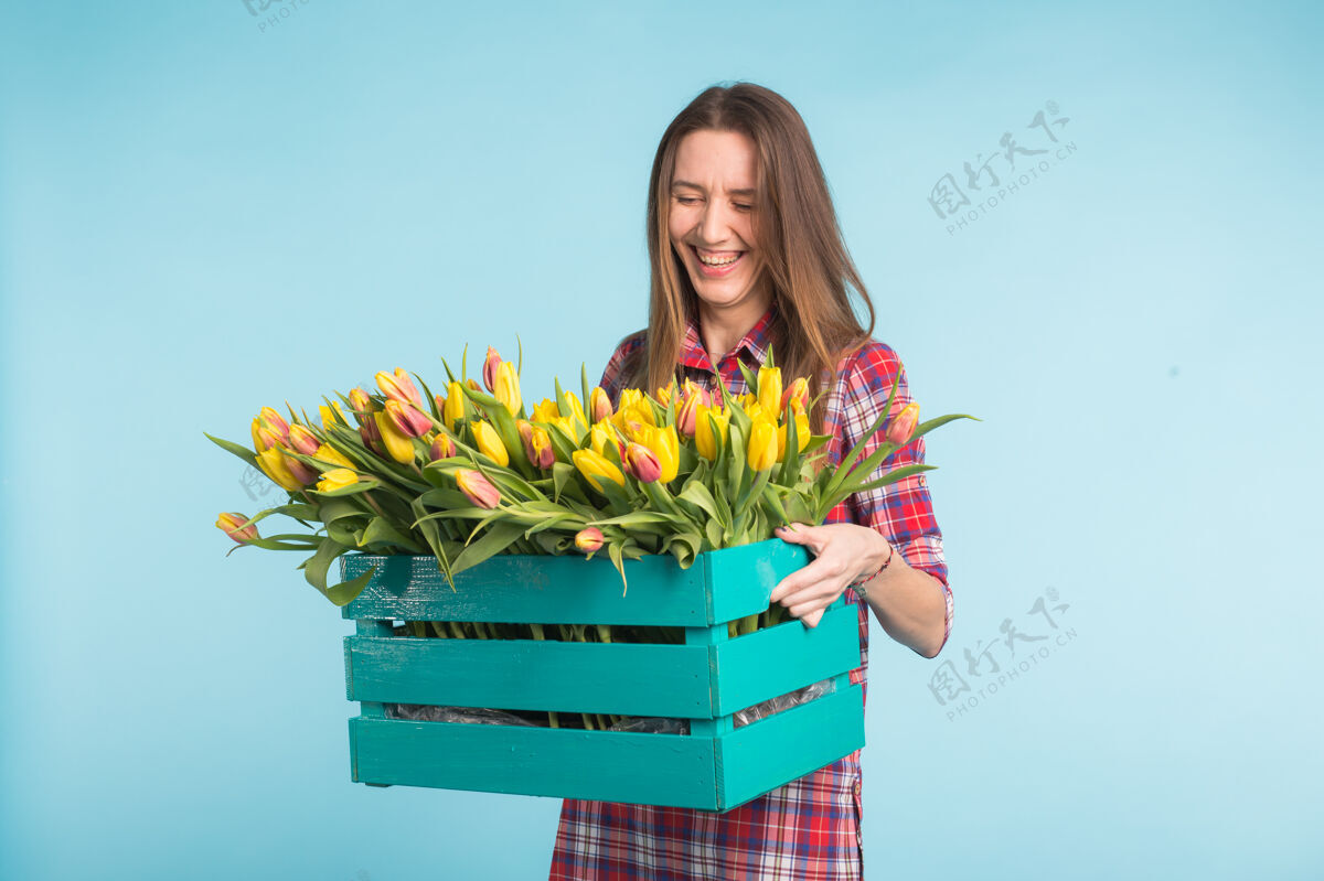 春天快乐的女人手拿花盒在演播室里笑女人女人束