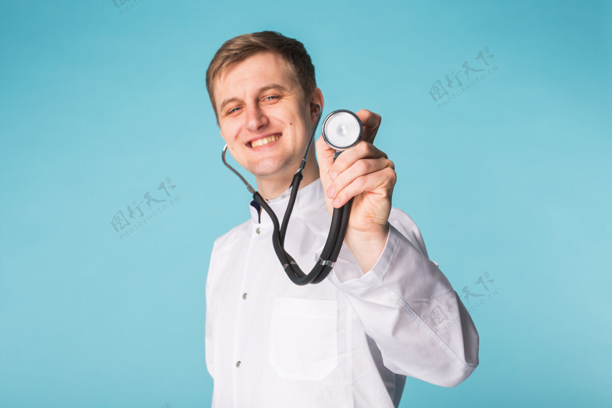 宏观医生用听诊器 靠近蓝色表面制服检查男性