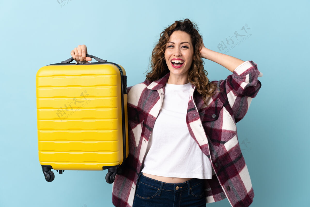 冒险年轻的白种女人孤独地在蓝色的度假旅行箱和惊喜手提箱行李手势