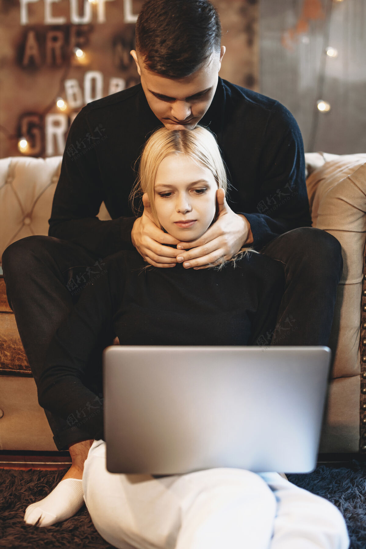 关系年轻漂亮的金发女郎坐在地板上靠着男友在家里用笔记本电脑工作人坐着空闲时间