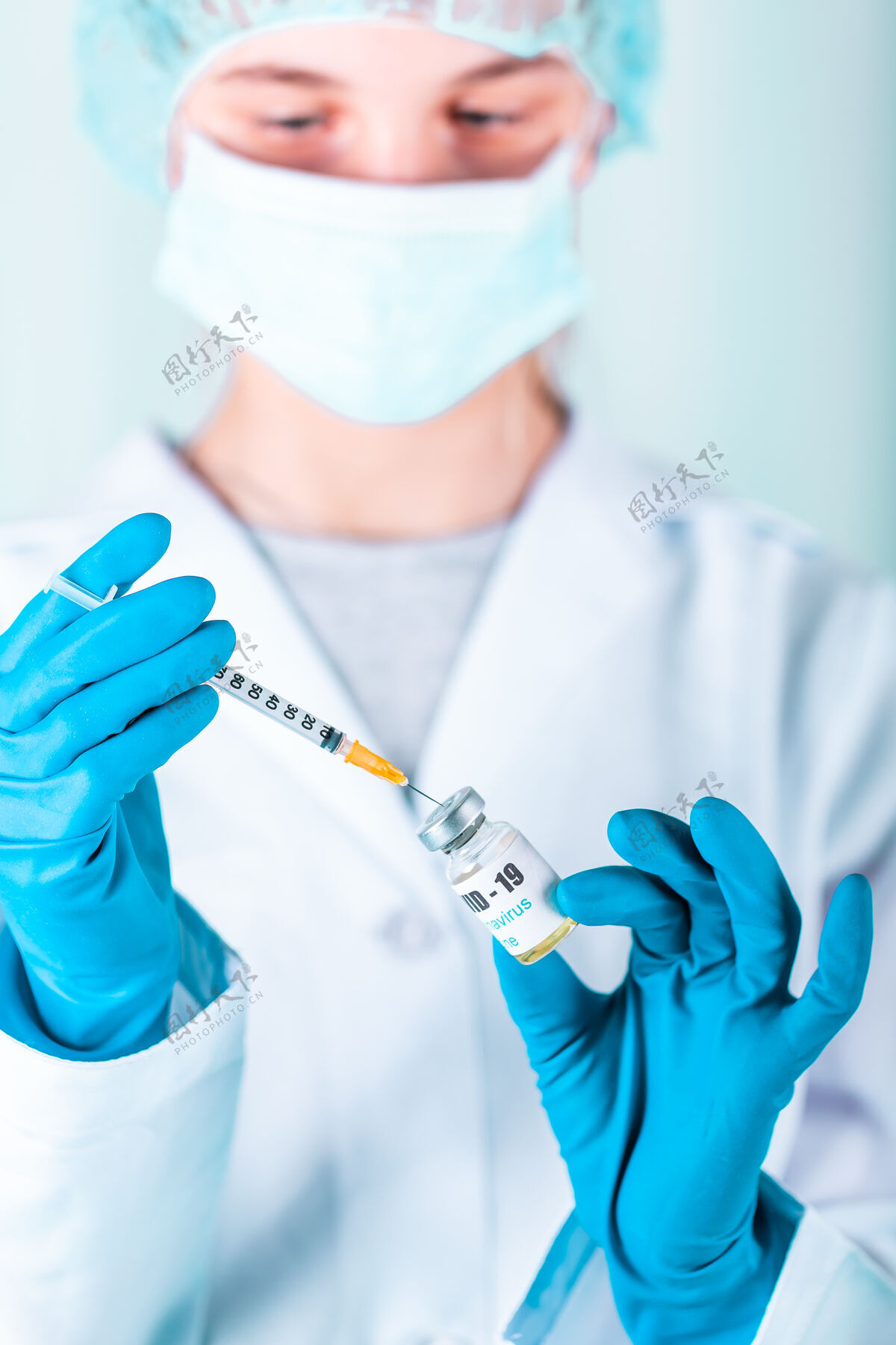 疫苗女医生或护士穿着制服 戴着手套 戴着口罩 在实验室里拿着带有冠状病毒疫苗标签的药瓶疫苗瓶护理针头手套