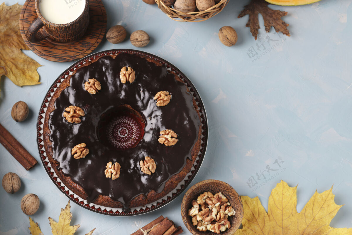 糕点自制南瓜松饼装饰着巧克力糖衣和核桃在浅蓝色零食健康新鲜