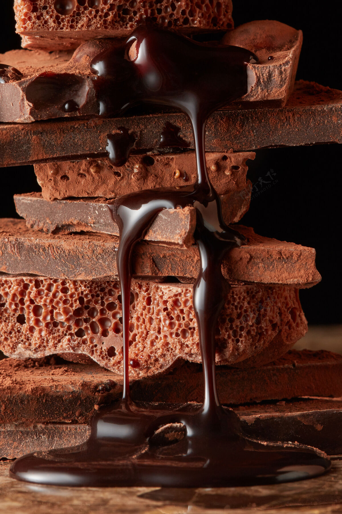 饮食巧克力糖浆滴在一堆黑巧克力上美味块块