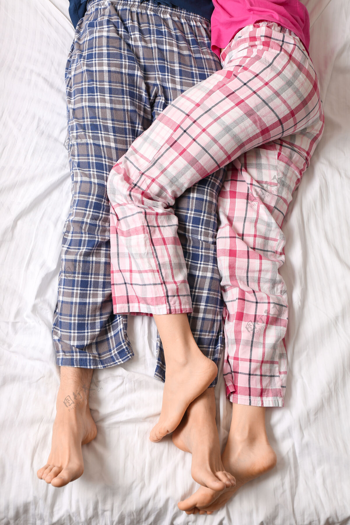 早起躺在床上的年轻夫妇 顶视图男人腿早晨