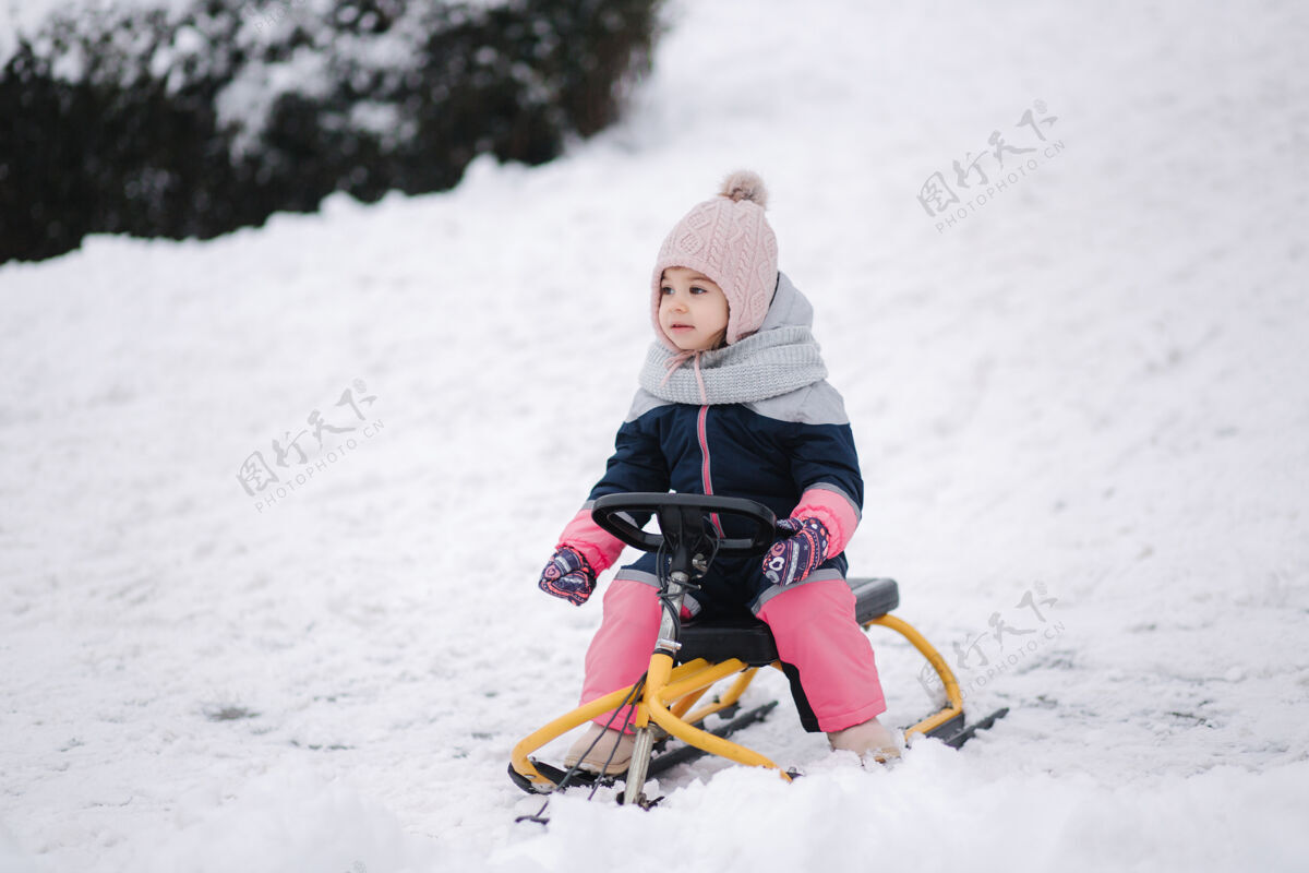 孩子小女孩喜欢坐雪橇骑年轻微笑