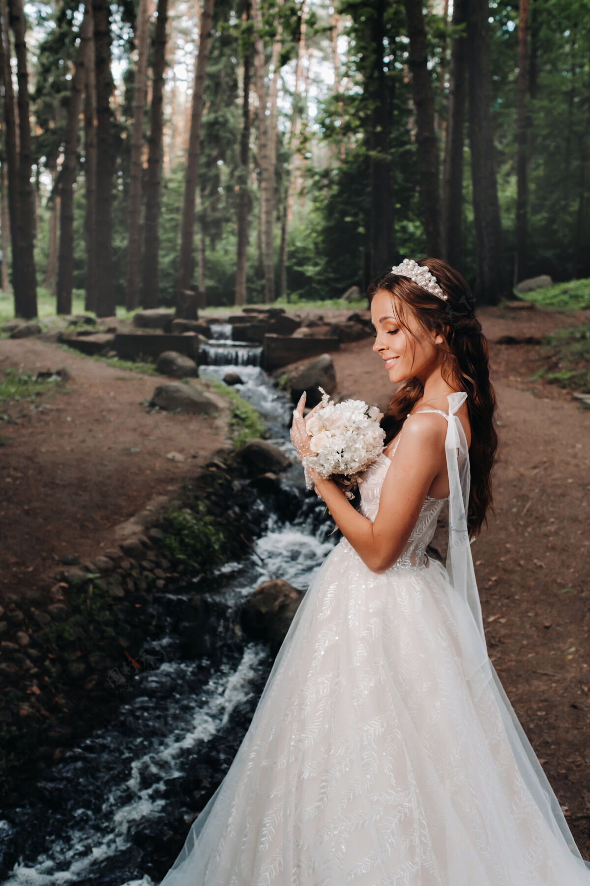 礼服一位优雅的新娘身穿白色礼服 戴着手套 手持花束 站在森林的小溪边女人可爱自由