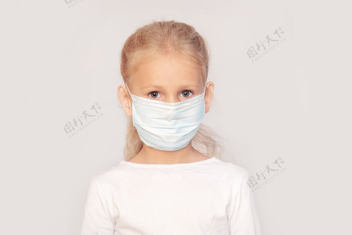 防护小女孩一个欧洲式的孩子 戴着医用面具 在一个孤立的背景下出现药物幼儿心烦
