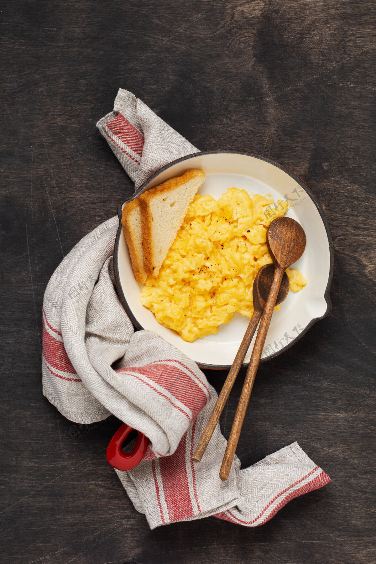 健康早餐用炒鸡蛋放在红色的旧煎锅上 深色的木桌上墙.传统英语早餐.上衣视野开阔煎蛋卷切炒菜