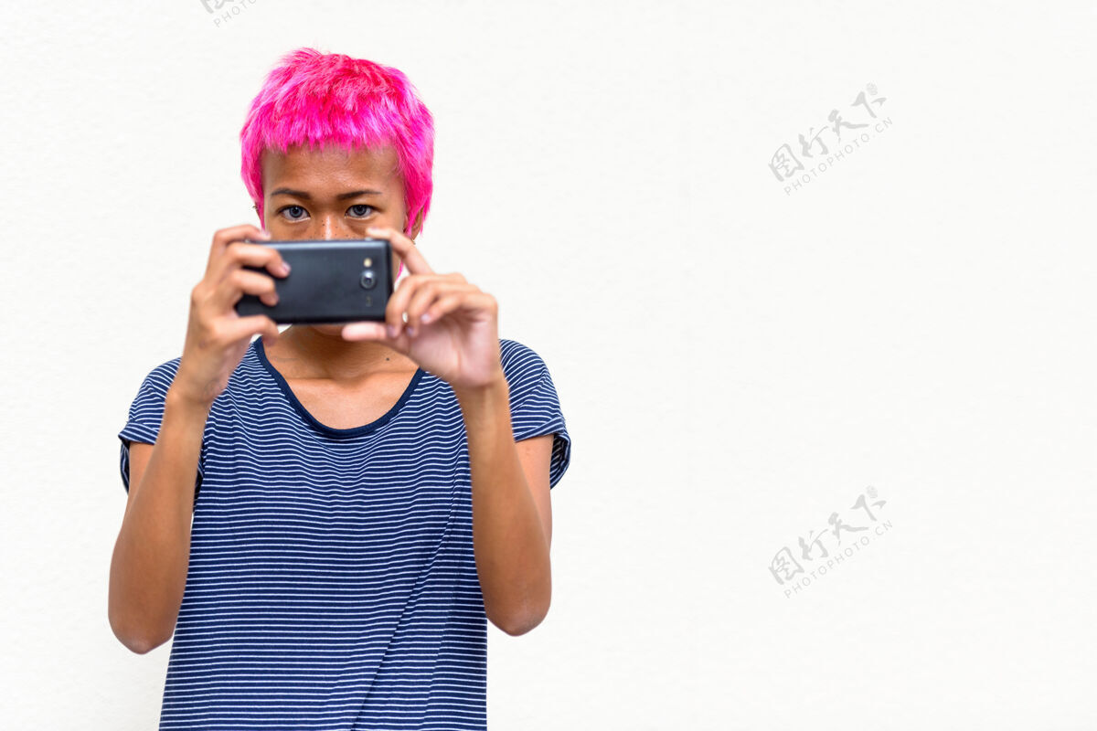 20多岁年轻叛逆的亚洲女人的肖像 粉色的头发映衬着白色的空间态度女性酷