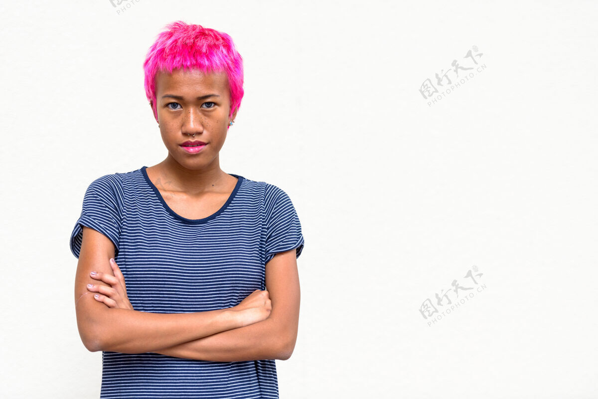 东南年轻叛逆的亚洲女人的肖像 粉色的头发映衬着白色的空间古怪穿孔酷