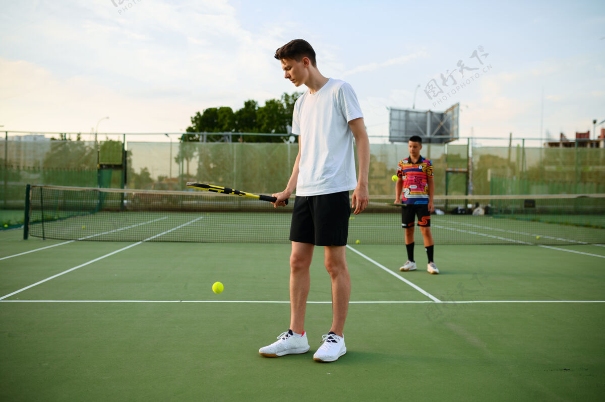 健身男子网球运动员用球拍击球 在户外训练court.活动健康的生活方式 人们玩体育游戏 健身锻炼与球拍动作球拍私人教练
